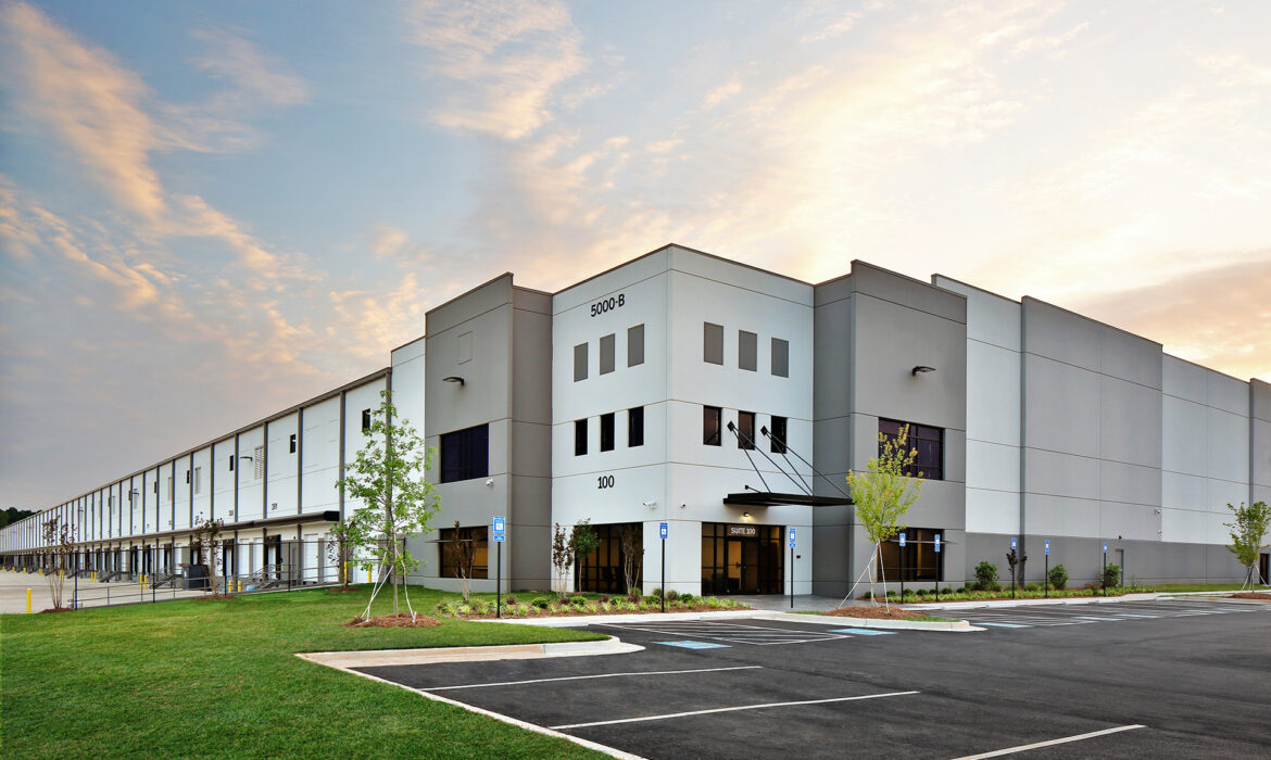Modern gray warehouse distribution facility at sunrise
