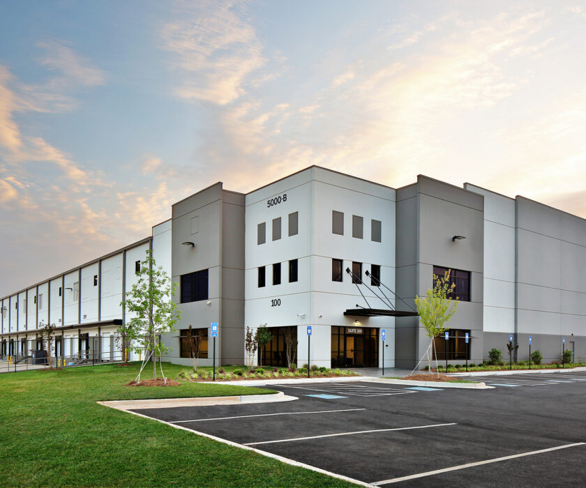 Modern gray warehouse distribution facility at sunrise